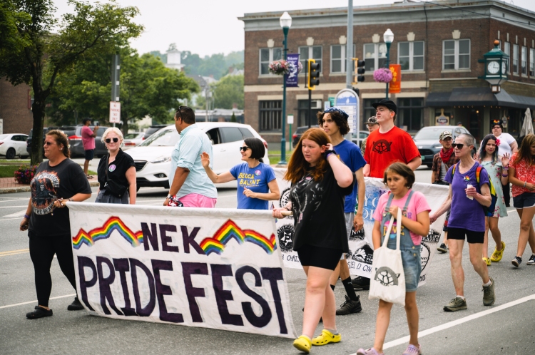 People marching with NEK PrideFest banner